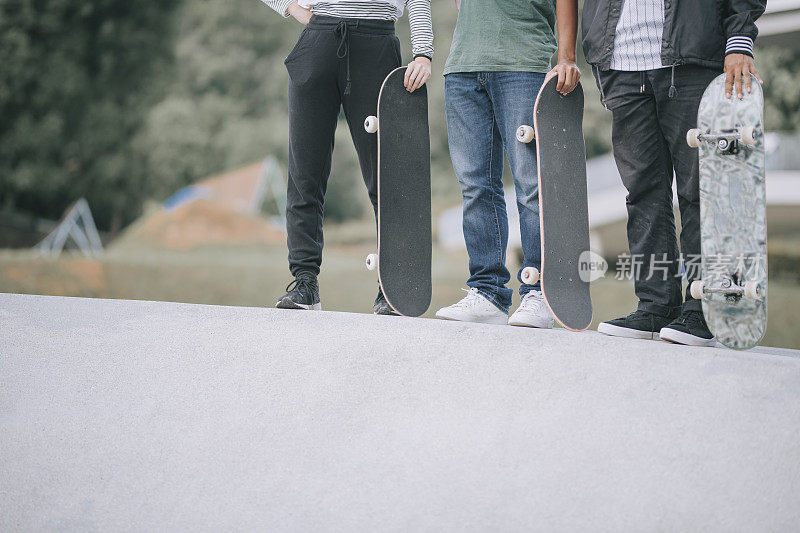 Asian skateboarders standing  at skateboard park